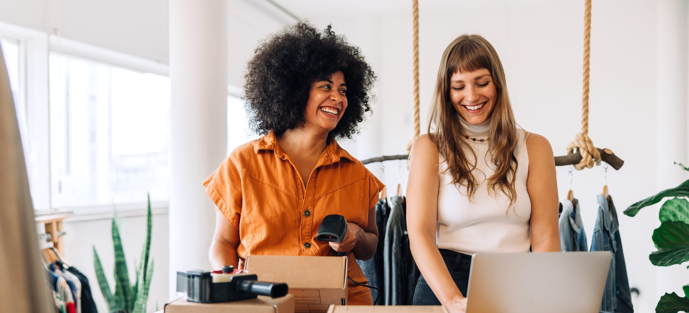 Two small business owners packing orders together in their shop
