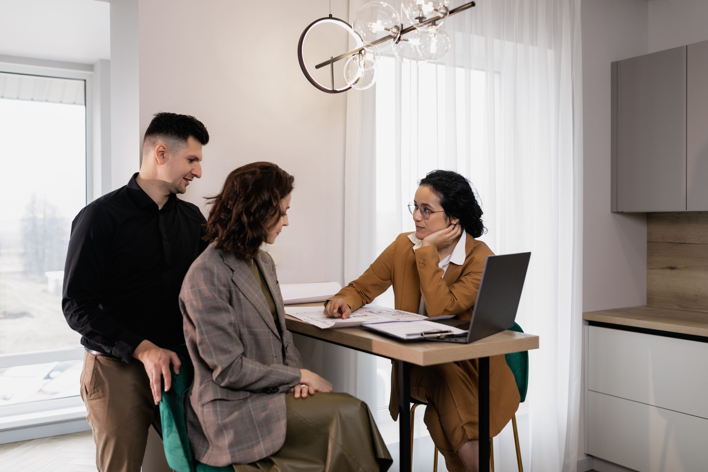 A couple going over plan documents with a financial strategist at a table